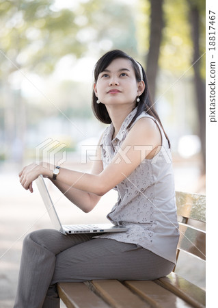Portrait of a smiling young business woman using laptop 18817467
