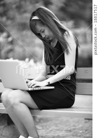 Beautiful young woman using laptop in park Beautiful young woman using laptop in park 18817517