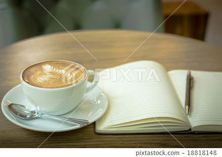 Hot latte art coffee cup on wooden table and note book, vintage Hot latte art coffee cup on wooden table and note book, vintage 18818148