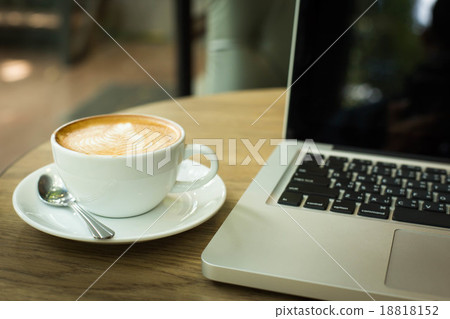 Hot art Latte Coffee in a cup on wooden table and and laptop in Hot art Latte Coffee in a cup on wooden table and and laptop in 18818152
