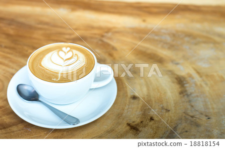 Hot art Latte Coffee in a cup on wooden table and Coffee shop bl Hot art Latte Coffee in a cup on wooden table and Coffee shop bl 18818154