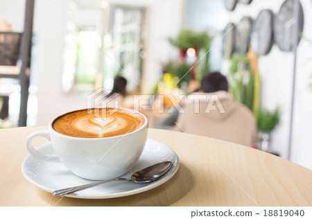 Hot art Latte Coffee in a cup on wooden table and Coffee shop bl Hot art Latte Coffee in a cup on wooden table and Coffee shop bl 18819040