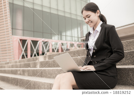 Young professional business woman sitting on the steps of an old Young professional business woman sitting on the steps of an old 18819252