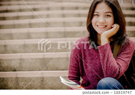 attractive female college student sitting on stairs 18819747