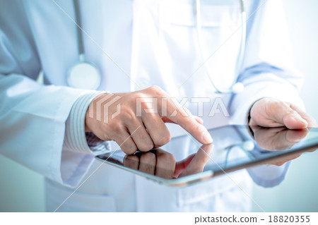 Stock Photo: Doctor working on a digital tablet