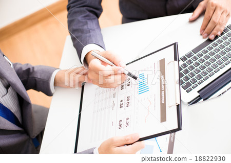 Two businessmen looking at report and having a discussion in off 18822930