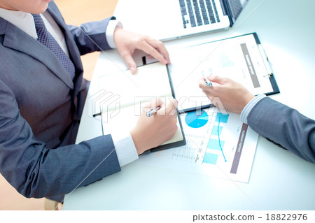 Two businessmen looking at report and having a discussion in off 18822976