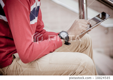 a student using a tablet on stairs 18824585