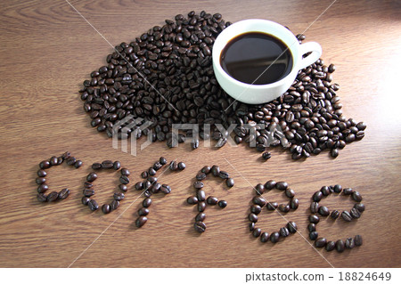White coffee cup resting on coffee beans and text Coffee on wood White coffee cup resting on coffee beans and text Coffee on wood 18824649