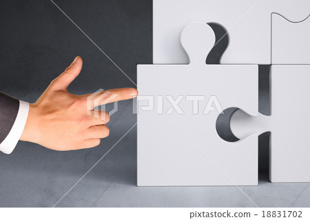 Businessman hand pushing puzzle piece Businessman hand pushing puzzle piece 18831702