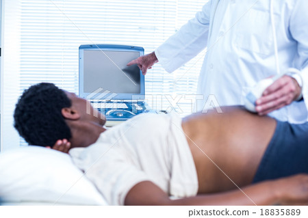 Doctor showing ultrasound results to pregnant woman Doctor showing ultrasound results to pregnant woman 18835889