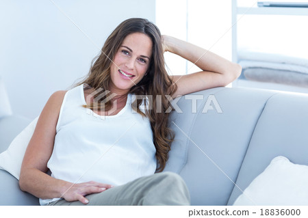 Happy pregnant woman sitting on sofa 18836000