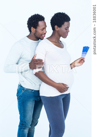 Pregnant wife holding color swatches while standing with husband Pregnant wife holding color swatches while standing with husband 18836001