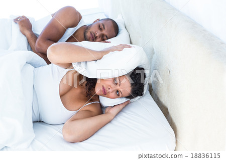 Stressed wife sleeping besides snoring husband Stressed wife sleeping besides snoring husband 18836115