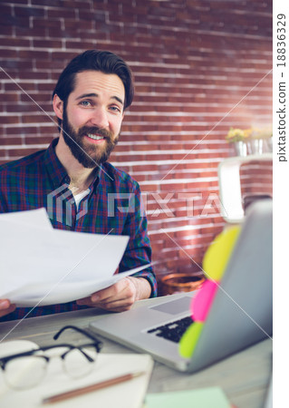 Portrait of smiling creative businessman with documents 18836329