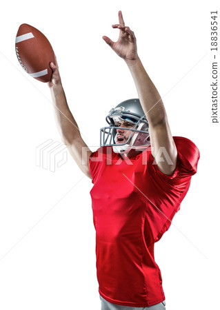 American football player holding ball while pointing up 18836541