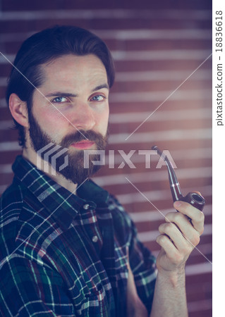 Portrait of confident hipster smoking pipe Portrait of confident hipster smoking pipe 18836618