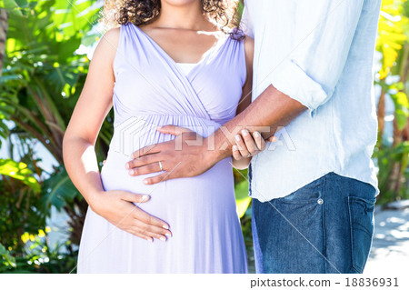 Midsection of pregnant wife with husband touching belly Midsection of pregnant wife with husband touching belly 18836931