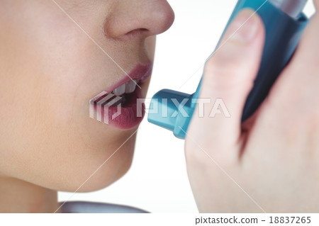 Asthmatic brunette using her inhaler 18837265