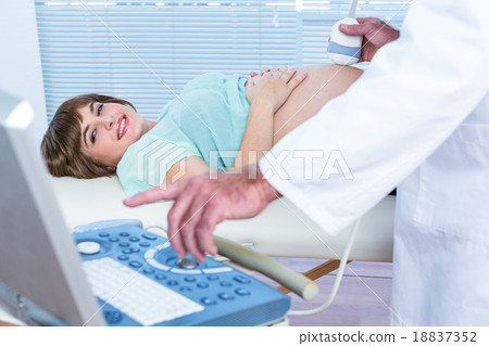 Doctor showing ultrasound monitor to happy pregnant woman Doctor showing ultrasound monitor to happy pregnant woman 18837352