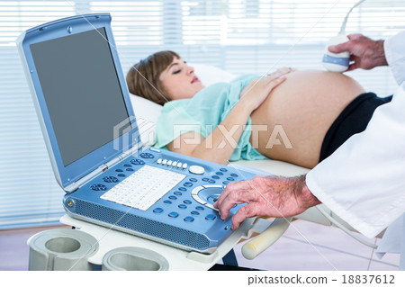 Pregnant woman lying while doctor performing ultrasound test 18837612