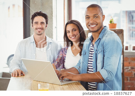 Portrait of smiling business people using laptop in office Portrait of smiling business people using laptop in office 18837627