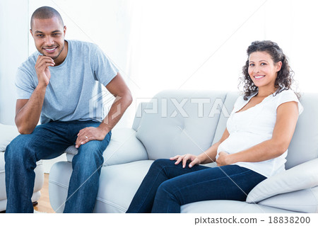 Portrait of couple sitting on sofa Portrait of couple sitting on sofa 18838200