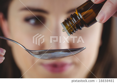 Pretty woman taking alternative tincture Pretty woman taking alternative tincture 18838481