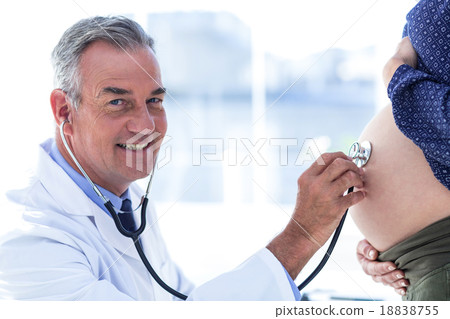 Portrait of male doctor examining pregnant woman in clinic Portrait of male doctor examining pregnant woman in clinic 18838755