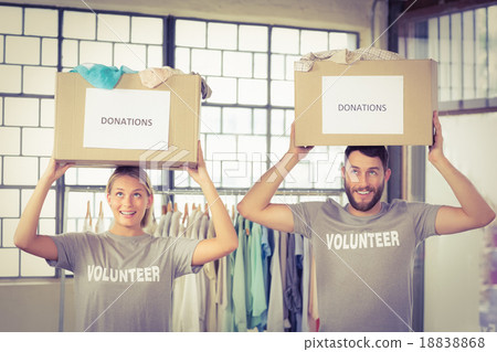 Volunteers carrying donation boxes on head 18838868