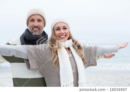 Cute couple standing with arms open wide Cute couple standing with arms open wide 18838987
