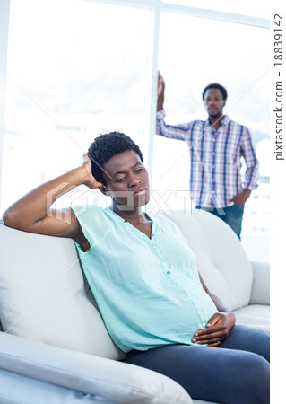 Depressed pregnant woman sitting on sofa 18839142