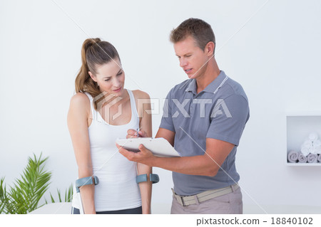Woman with crutch speaking with his doctor Woman with crutch speaking with his doctor 18840102
