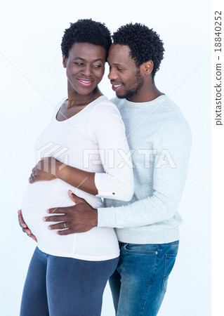 Husband touching pregnant wife belly while standing 18840252