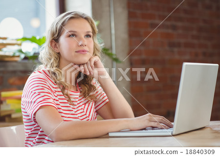 Thoughtful woman using laptop in office Thoughtful woman using laptop in office 18840309
