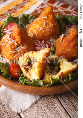 arancini with meat and peas close-up on a plate 18842692