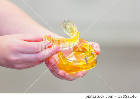 Hand holding a set of dentures Hand holding a set of dentures 18852146