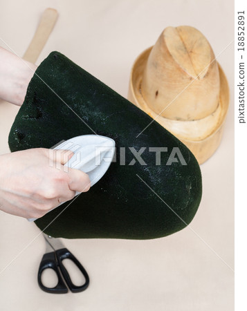 hatter gluing a felt hood for shaping on dummy 18852891