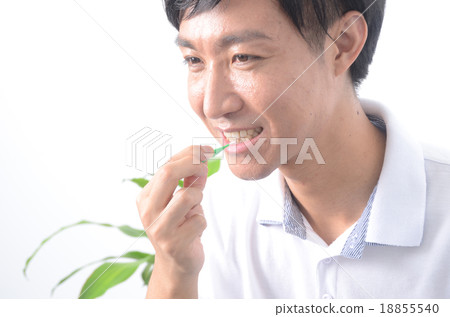 A man who brushes with an interdental brush 18855540