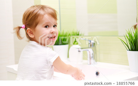 Stock Photo: child little girl washes her hands in bathroom