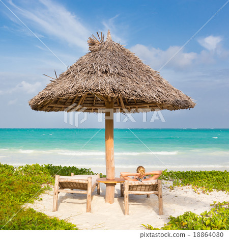 Woman sunbathing on tropical beach. Woman sunbathing on tropical beach. 18864080