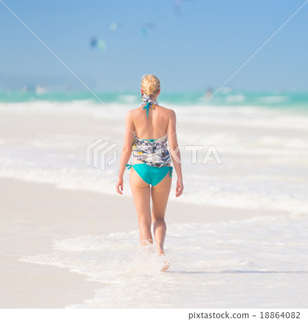 Woman walking on the beach. Woman walking on the beach. 18864082