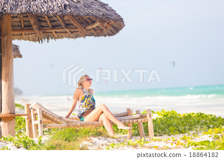 Woman sunbathing on tropical beach. Woman sunbathing on tropical beach. 18864182