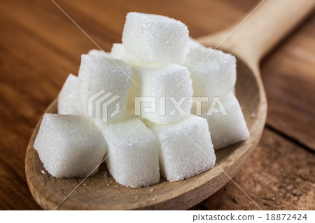 Sugar Cubes on Wooden Spoon over Wooden Background Sugar Cubes on Wooden Spoon over Wooden Background 18872424