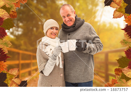 Composite image of happy mature couple in winter clothes holding Composite image of happy mature couple in winter clothes holding 18873757