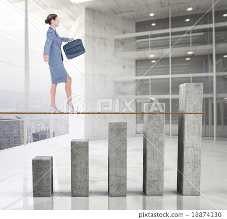 Composite image of businesswoman walking tightrope 18874130