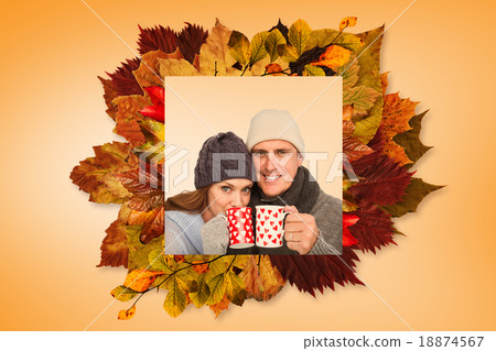 Composite image of happy couple in warm clothing holding mugs 18874567