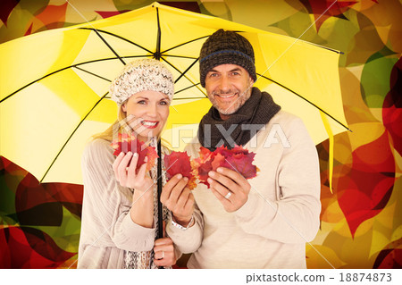Composite image of portrait of couple holding autumn leaves whil Composite image of portrait of couple holding autumn leaves whil 18874873