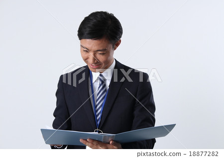 A smiling businessman looking at the file 18877282