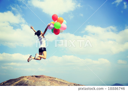 woman mountain peak jumping with balloons woman mountain peak jumping with balloons 18886746